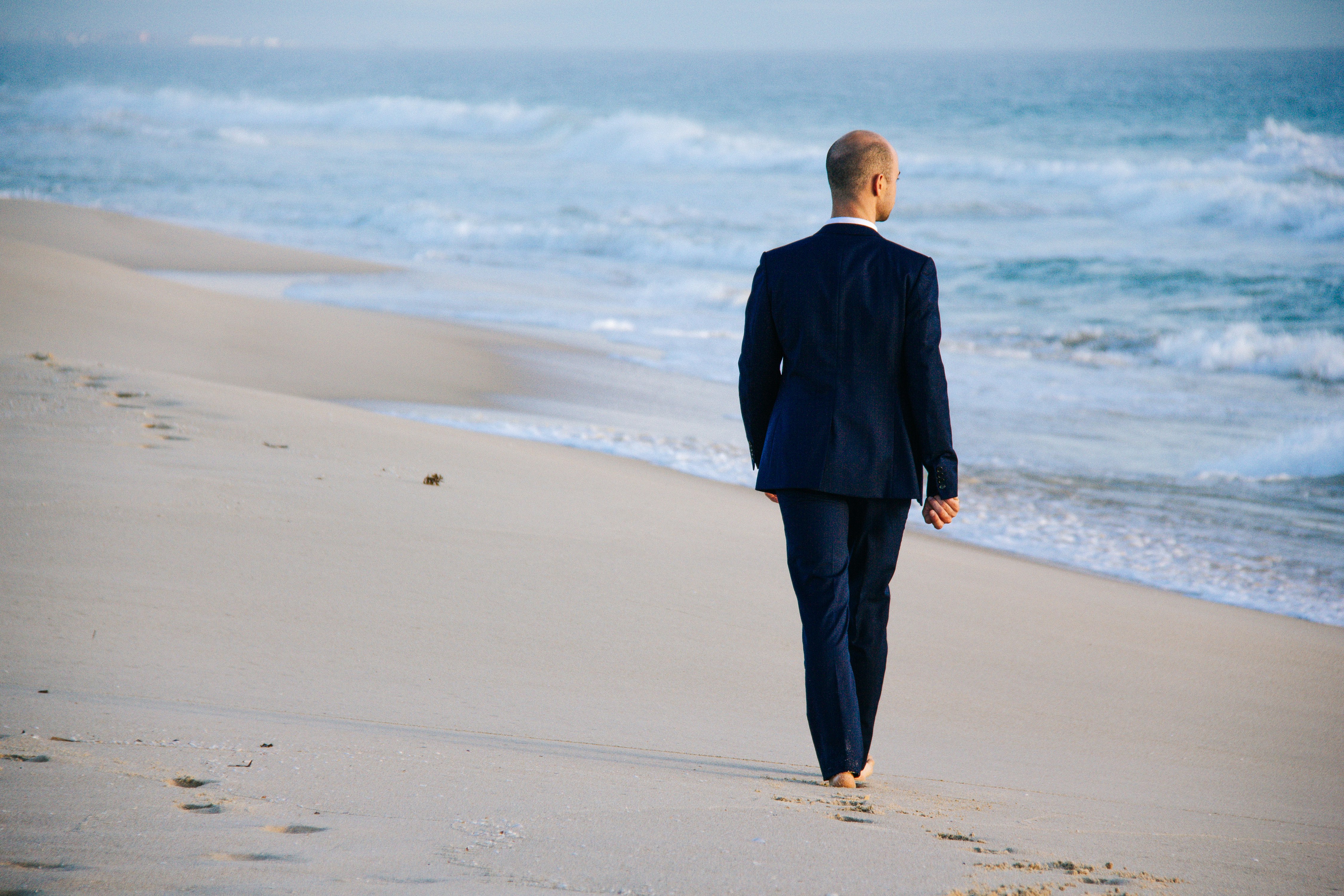 man walking on shore during daytime